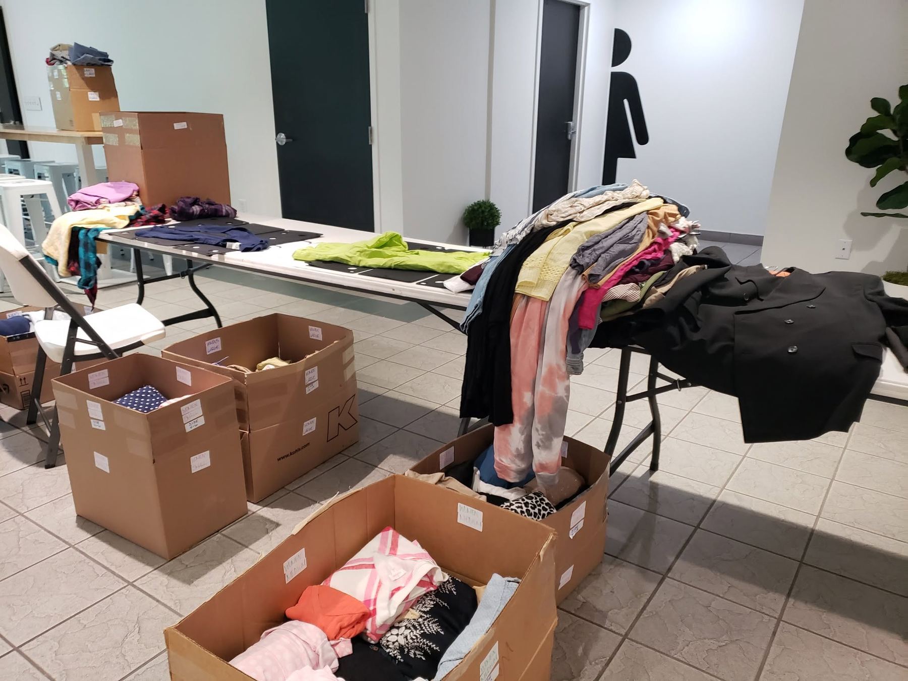 Clothing sorting room with tables and labeled boxes