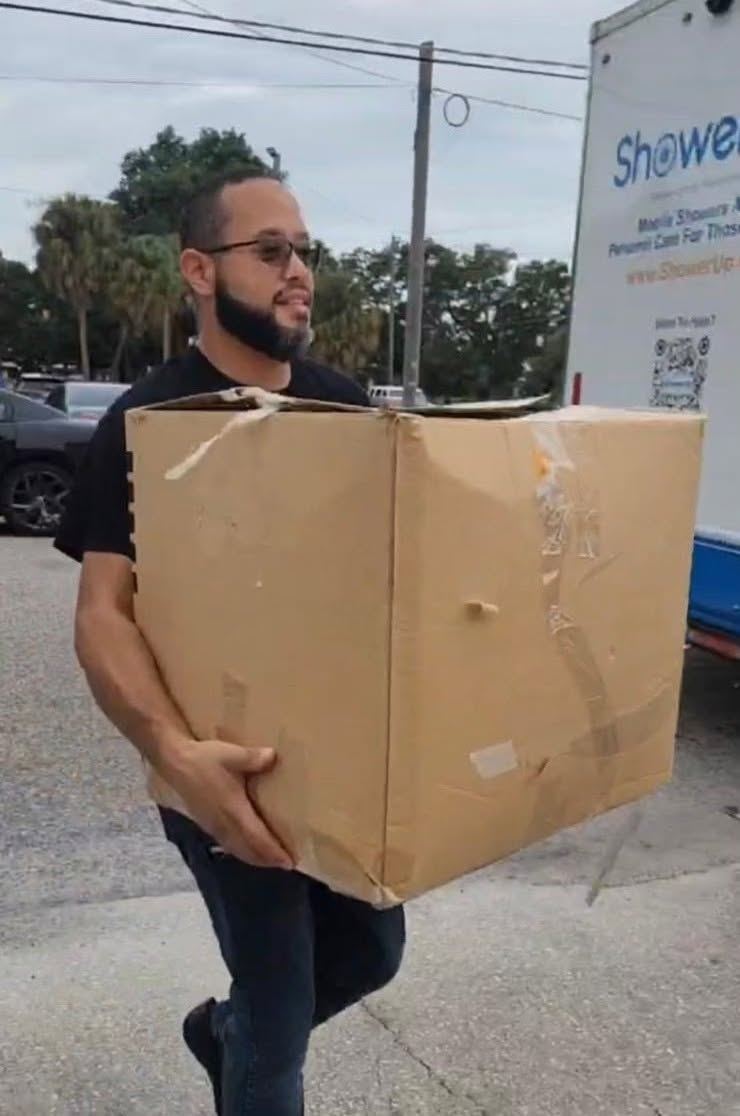 FFF team member carrying donated supplies for community outreach