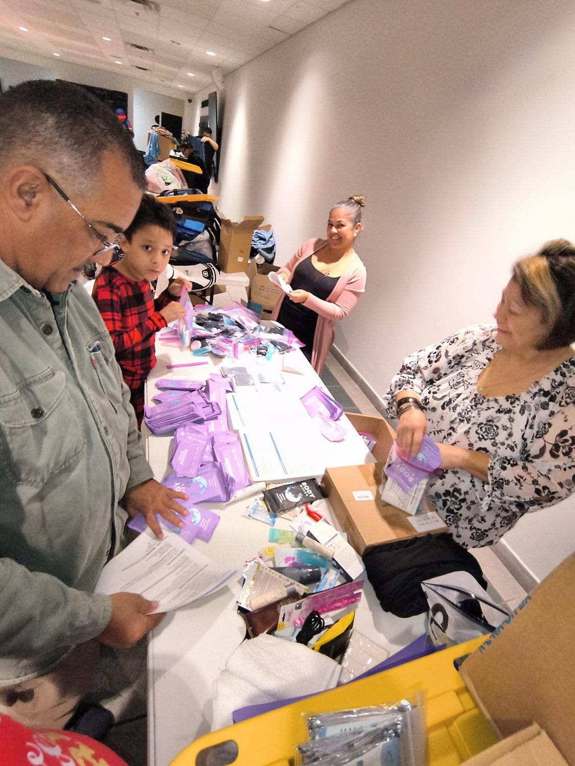 Family and volunteers packing hygiene kits