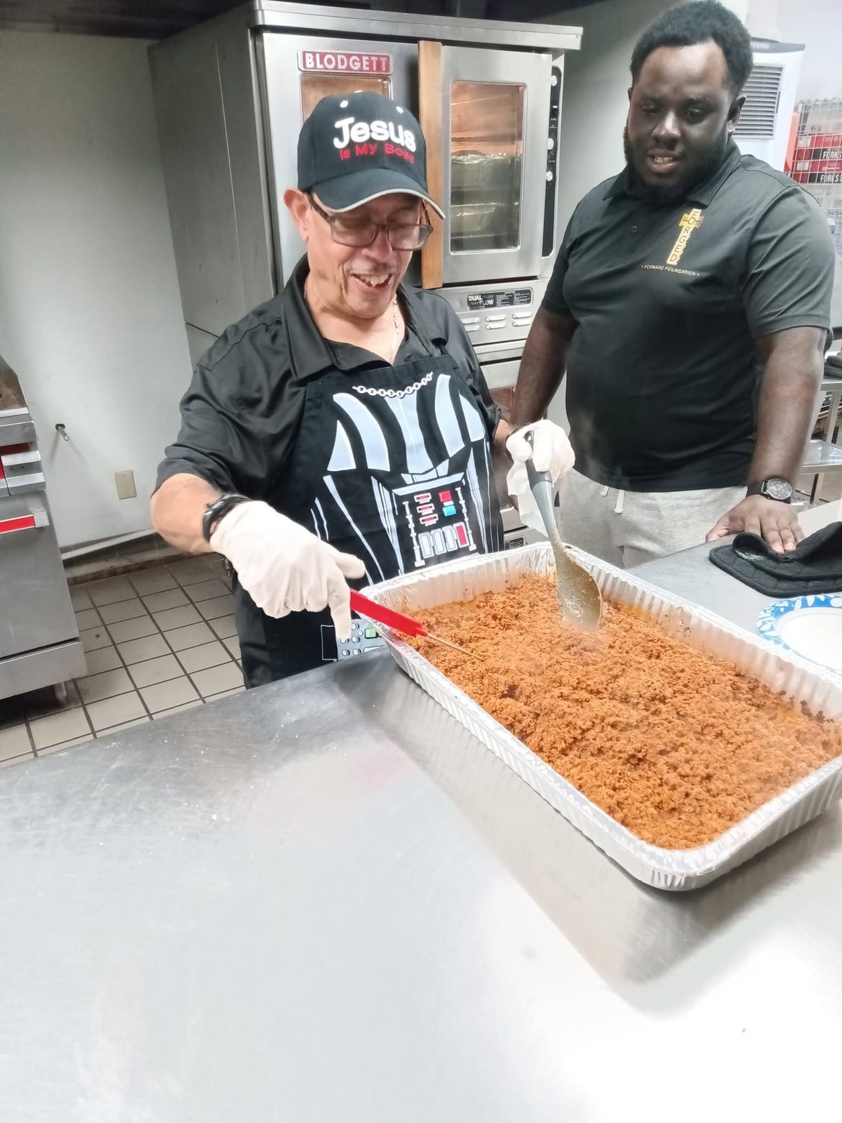 FFF volunteer smiling while preparing food for outreach